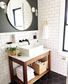 a bathroom with a sink, mirror and towel rack in it's center area