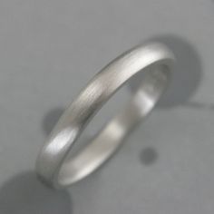 Platinum 3mm Wide Comfort Fit Band Platinum Wedding Ring Handmade Platinum Wedding Ring Rounded Exterior and Interior Ring Made Just for YOU Our simple 3mm wide by 2mm thick rounded comfort fit design in elevated in solid platinum! If you are looking for a simple, comfortable modern ring that will last through many lifetimes, this is the band for you! Hand forged in our studio to size just for you, your ring can either be high polished or brushed. We also offer engraving services for a personalized touch. Platinum is one of the most difficult metals to work in. I have put my 20+ years of experience into branching out into platinum designs. It's by far the most durable of metals and my own wedding set is platinum. We use 950 Platinum/Ruthenium. The Ruthenium alloy is the best alloy for fabr Wedding Ring With Smooth Finish And Round Band, Wedding Band With Smooth Finish, Wedding Rings With Smooth Finish And Round Band, Wedding Rings With Smooth Finish, Wedding Rings With Thick Band And Smooth Finish, Minimalist Wedding Bands With Smooth Finish, Simple Polished Stackable Wedding Rings, Simple Silver Stackable Wedding Rings, Simple Silver Stackable Rings For Wedding