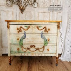 an old dresser has been painted with peacocks on it and gold trimming around the drawers