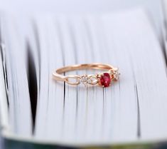 a close up of a gold ring with a red and white stone on it's side