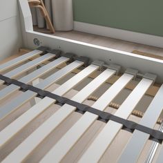 a close up of a bed frame with wooden slats on the bottom and sides