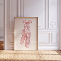 a pink ballet shoe is hanging on the wall next to a framed photograph in an empty room