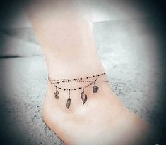 a small ankle tattoo with musical notes and keys on the ankle, along with beads