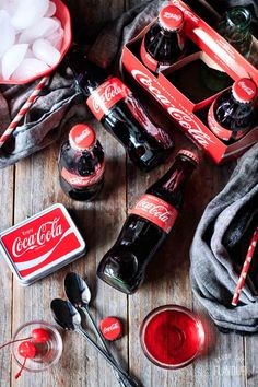 coca - cola bottles, spoons, and ice cubes on a wooden table