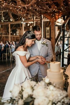 a bride and groom cutting their wedding cake