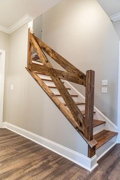 an empty room with a wooden staircase and hard wood flooring on the side wall