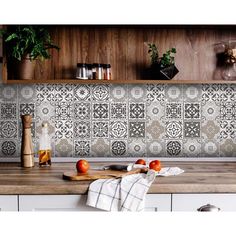 a wooden table topped with fruits and vegetables on top of a kitchen counter covered in potted plants