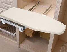 a white ironing board sitting on top of a cabinet