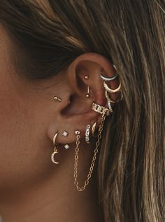 a close up of a person wearing ear piercings with chains attached to their ears