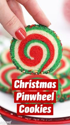 a hand picking up a candy roll from a white plate on a red and green tablecloth