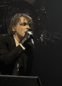 a man in a suit singing into a microphone