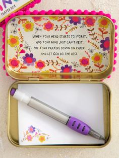 an open tin box with a pen in it