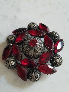 This is a vintage red, glass rhinestone and steel cut brooch. My best guess is that this is from the 1940s. I think it may be older however. It is really a stunning piece. The brooch measures about 2 inches across. Don't forget to stop in at my other Etsy shop... http://www.etsy.com/shop/xtdesigns. Follow me on Twitter at... MyYiayiaHadThat@MyYiayiaHadThat. If you have a wish list or are looking for something specific, please ask. I may have exactly what you are looking for. As always please con Vintage Red Jewelry With Rhinestones, Vintage Red Brooches For Formal Occasions, Vintage Red Rhinestone Jewelry, Red Retro Brooch Jewelry, Retro Red Brooch Jewelry, Vintage Red Brooches For Party, Antique Red Wedding Brooch, Vintage Red Wedding Brooches, Vintage Jewellery Rings