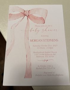 a baby shower card with a pink bow on it