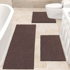 two bathroom rugs on the floor in front of a bathtub and toilet,