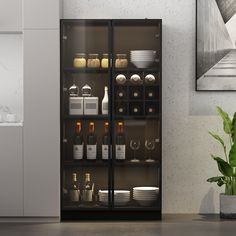 a glass cabinet filled with lots of bottles and glasses next to a potted plant