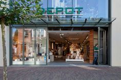 the entrance to a store with people standing in it's glass doors and windows