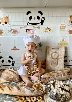 a baby sitting on the floor with bread and doughnuts