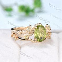 a ring with an oval cut green stone surrounded by yellow and white cubicgeach stones