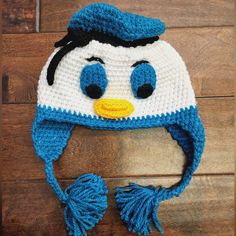 a crocheted penguin hat on top of a wooden floor