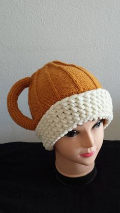 an orange and white knitted hat on top of a mannequin's head