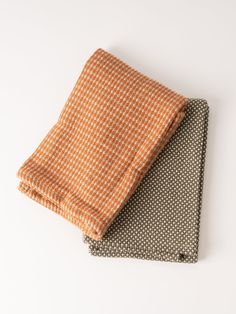 an orange and brown checkered cloth folded on top of each other