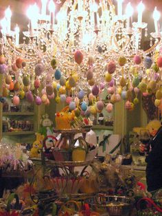 a woman standing in front of a store filled with lots of colorful balls and decorations