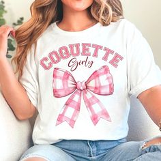 a woman sitting on a couch wearing a t - shirt that says coquette gay