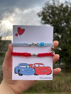 two bracelets with cars on them are being held in front of a card that says i love my mom