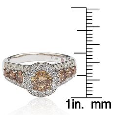 This unique engagement ring features a brown round-cut cubic zirconia center stone with white and brown cubic zirconia side stones. The band is crafted from high polish sterling silver to complete the glamorous look of the ring. Center Stone: 1 brown cubic zirconia Round-cut Prong setting Gemstone weighs 1.25 carats Side Stones: 48 cubic zirconia Brown and white color Pave setting Round-cut Metal information and dimensions: Engagement ring Halo style Sterling silver High polish Ring setting 21 m Brown Diamond Ring Fine Jewelry, Brown Diamond Ring With Diamond Accents For Anniversary, Brown Diamond Ring With Accents For Anniversary, Anniversary Brown Diamond Ring With Accents, Brown Round Diamond Ring In Fine Jewelry Style, Brown Diamond Ring In Fine Jewelry Style, Brown Prong Set Ring For Anniversary, Fine Jewelry Brown Diamond Ring, Brown Prong-set Ring For Anniversary