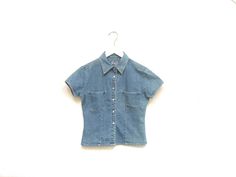 Vintage 90s womens little denim collared shirt. Six pearl snap button closures. Two chest pockets. Short sleeves. Fitted. Southwestern cowgirl bohemian vibes. A wild west top for a adventurous someone. Label: Real Clothes Jeans Fits Like: Marked womens S Color: Medium wash blue denim Fabrication: Cotton denim Condition: Great used condition, normal signs of wear 17" chest 15.5" shoulder 17" length 5" sleeve all measurements taken while garment lying flat This item comes from a pet & smoke free building For a look behind the scenes: + Instagram: brotherxiivintage Jeans Fits, Clothes Jeans, Denim Shirt With Jeans, Rodeo Shirts, Jean Shirt, Bohemian Vibes, Collared Top, Denim Blouse, Cow Girl