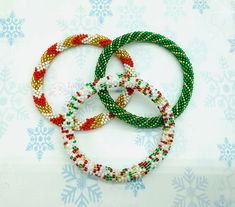 three colorful bracelets sitting on top of a table covered in snowflakes and snow flakes