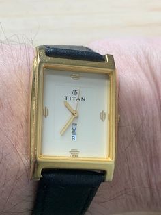 TITAN Gents Day Date Cream Dial Quartz watch In the deco Style Practical, hardwearing and reliable watches from Titan.  This Is a Gents 26.3mm watch, the watch was sold as a Gents watch but could be a unisex watch due to its size The watch has a gold-tone rectangular case with a cream dial in the  deco tank style the dial is signed Titan with deco style markers at the 12,3,6 and 9 with the day and date above the 6 The back of the watch is signed Titan 1185YAD india Fitted with a Black Leather st Classic Analog Watch With Rectangular Dial, Classic Analog Jewelry And Watches With Rectangular Dial, Business Rectangular Watch With Date Indicator, Modern Rectangular Watches With Date Indicator, Rectangular Business Watches With Date Indicator, Formal Rectangular Analog Watch, Elegant Gold Watch Band With Date Indicator, Elegant Gold Watch Bands With Date Indicator, Classic Rectangular Watch With Analog Display