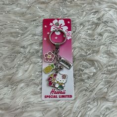 a hello kitty keychain is sitting on a fur surface with the name hawaia special limited