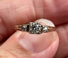 a close up of a person's hand holding an old fashioned ring