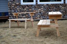 two wooden benches sitting in front of a stone wall next to a building with windows