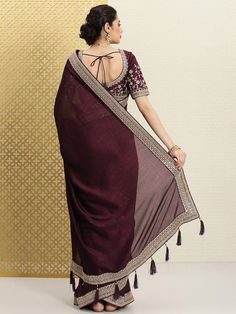 Burgundy and gold-toned sareeSolid solid saree with woven design borderHas sequinned detailThe saree comes with an unstitched blouse pieceThe blouse worn by the model might be for modelling purpose only. Check the image of the blouse piece to understand how the actual blouse piece looks like.