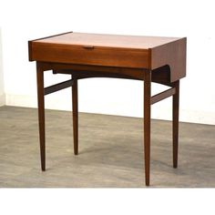 a small wooden desk with one drawer open