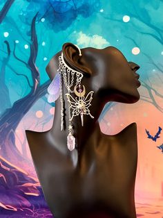 a mannequin head with jewelry on it in front of a tree and sky background