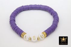 Purple and Gold Bracelet in Heishi Beads by Regina Harp Designs These bracelets are in a purple, white and gold colors with your choice of bracelet style. They can be made with our other bead colors as well; message us if you would like to customize your bracelet. If you need a smaller or extra large size in the bracelet, please leave us a note with your order. To measure your wrist size you can wrap a piece of string around your wrist and mark it. Then lay the string down and see how long it is Adjustable Purple Heishi Beads Bracelets, Purple Stretch Bracelet With Letter Beads, Purple Heishi Beaded Bracelets With Letter Beads, Purple Heishi Beads Bracelet With Letter Beads, Personalized Purple Round Beads Stretch Bracelet, Personalized Purple Stretch Bracelet With Round Beads, White And Gold Bracelet, Beaded Bangles, White Jewelry Box