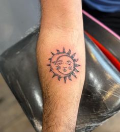 a man with a sun and moon tattoo on his arm