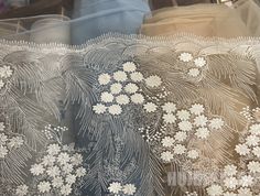 some white flowers and leaves on sheer fabric