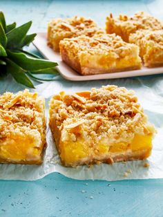 three pieces of dessert sitting on top of wax paper next to a pineapple plant