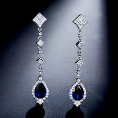 A delightfully unique pair of bridal earrings with an incredible sparkle! Adorned with flawlessly faceted cubic zirconia that capture the light in a dazzling array of sparkles, the earrings are rhodium plated for a bright finish which enhances the intricate detailing and conveys a modern take on old elegance. Length: 2" (approx. 5.2cm); Width: 0.4" (approx. 1cm). Weight: 3g/earring. Available with Blue and Clear stones. To make your choice select your preferred color from the dropdown menu to ad Classic Cubic Zirconia Chandelier Earrings For Formal Occasions, Classic Formal Chandelier Earrings In Cubic Zirconia, Elegant Diamond Cut Cubic Zirconia Chandelier Earrings, Elegant Cubic Zirconia Chandelier Earrings With Diamond Cut, Elegant Chandelier Earrings With Diamond Cut Cubic Zirconia, Dazzling Sparkling Diamond Earrings For Formal Occasions, Dazzling Diamond White Crystal Bridal Earrings, Dazzling Cubic Zirconia Bridal Earrings, Diamond White Crystal Drop Bridal Earrings