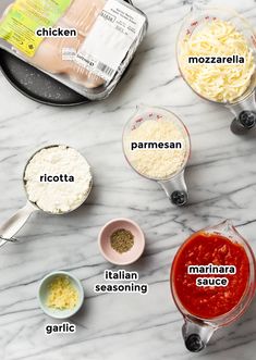 the ingredients for making pasta in small bowls on a marble counter top, including parmesan cheese, marinara sauce and chicken