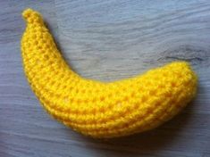 a crocheted banana sitting on top of a wooden table