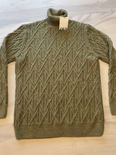 a green sweater with an interesting design on it