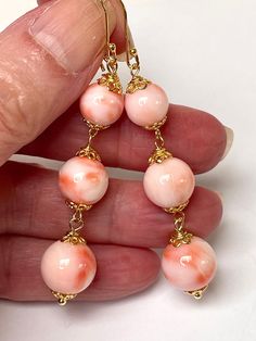 Vintage AA Grade Pink Angel Skin Precious Coral Round Beads, Handmade Bali 24K Gold Vermeil Bead Caps, Bali Handmade 24K Gold Vermeil French Ear Wires Vintage genuine precious coral UNDYED natural beads that were hand selected by us in Taiwan in the early 1980's create a simple yet dramatic long dangling graduated bead earring.  The two beautiful bottom beads each measure approximately 1/2" in diameter ( or approximately 12mm - there are 25mm to the inch ).  The middle beads are 11mm and the top beads are 9mm.                                                         Total weight of the 6 beads is 10.8 grams. The color is superb as you can see in the photos - the beads have a beautiful polish and are lovely and round.  Coral beads in these larger sizes like the bottom 12mm beads are getting Elegant Dangle Beaded Earrings With Large Beads, Elegant Large Beaded Dangle Earrings, Elegant Round Earrings With Large Beads, Elegant Adjustable Beaded Earrings With Beaded Chain, Elegant Beaded Earrings With Large Beads, Elegant Adjustable Beaded Earrings, Elegant Coral Jewelry With Large Beads, Dramatic Earrings, Angel Skin