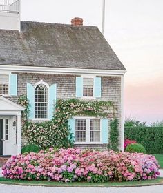 a house that has flowers in front of it