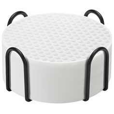 a white cake plate with black handles and holes on it's sides, set against a white background